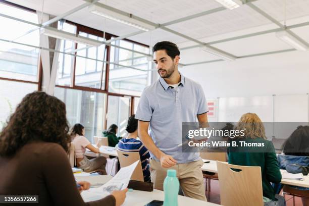 teacher handing tests out to pupils - teachers imagens e fotografias de stock