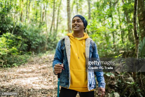 若い男が目をそらし、トレイルで熟考する - 登山用ストック ストックフォトと画像