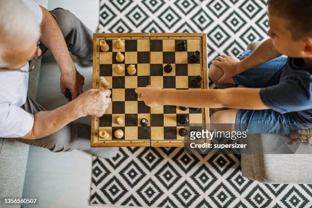 großeltern mit ihren enkeln - chessboard stock-fotos und bilder