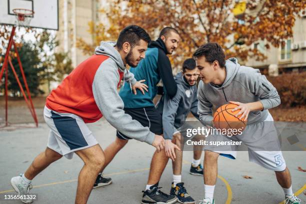 freunde spielen draußen basketball - basketball verteidiger stock-fotos und bilder