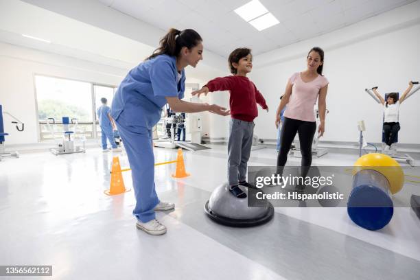 junge macht gleichgewichtsübungen für seine physiotherapie in einem reha-zentrum - sportmedizin happy stock-fotos und bilder