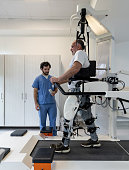 Senior man walking with an exoskeleton while doing physiotherapy