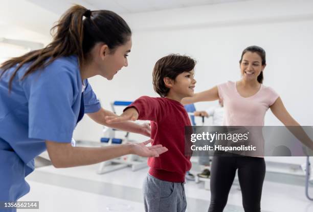 boy working on his balance in physical therapy at a rehab center - coluna vertebral humana imagens e fotografias de stock