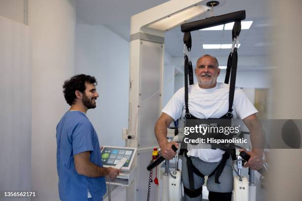 man using an exoskeleton for walking during physical therapy - powered exoskeleton stock pictures, royalty-free photos & images