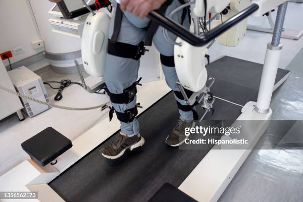 gros plan sur un homme utilisant un exosquelette motorisé pendant sa thérapie physique - exosquelette photos et images de collection