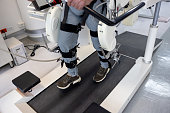 Close-up on a man using a powered exoskeleton during his physical therapy