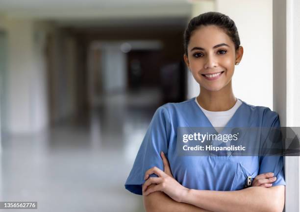 schöne krankenschwester lächelt im krankenhaus - frontline worker stock-fotos und bilder