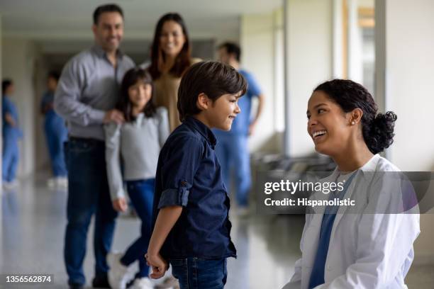 pediatra felice che parla con un ragazzo in ospedale - medical examination of young foto e immagini stock