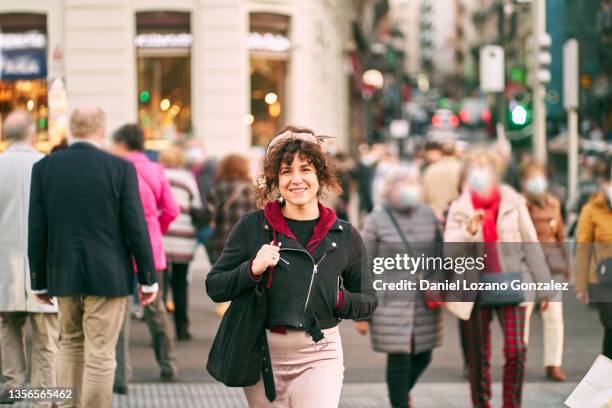 smiling woman crossing crowded road in crosswalk - madrid people stock pictures, royalty-free photos & images