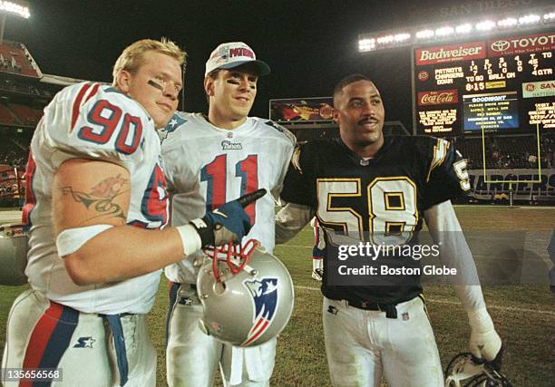 The Washington State connection poses for a photo after the game, alums Chad Eaton, Drew Bledsoe and Lew Bush with the final on the scoreboard behind...