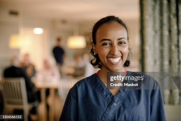 portrait of smiling female nurse at retirement home - enfermero fotografías e imágenes de stock