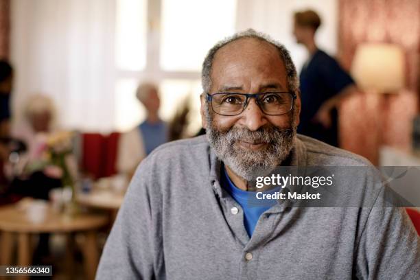 portrait of senior man in retirement home - septuagénaire photos et images de collection