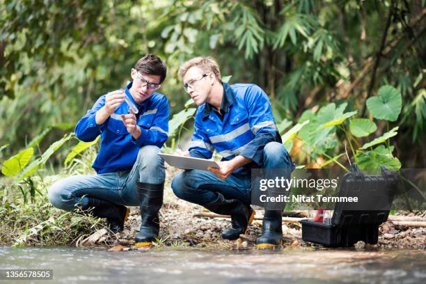 scientists collect river water quality data and take notes in a checklist. field testing for research water quality. - water margin stock pictures, royalty-free photos & images