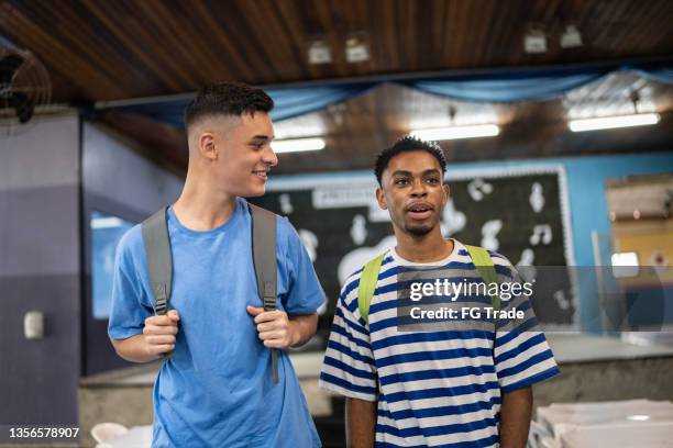two teenage boys talking in the school cafeteria - boy talking stock pictures, royalty-free photos & images