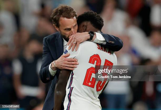 England manager Gareth Southgate consoles his player Bukayo Saka after his decisive miss in the penalty shootout gave Italy victory during the Italy...