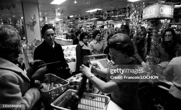 Achats pour les fêtes de Noël et passage en caisse au "Printemps" en 1976 à Paris.