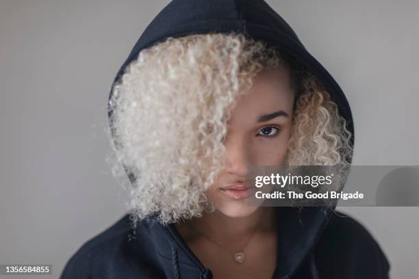 portrait of young woman wearing black hoodie - platinum blonde hair stock pictures, royalty-free photos & images