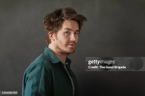 portrait of mid adult man wearing green shirt - mann portrait seitlich stock-fotos und bilder