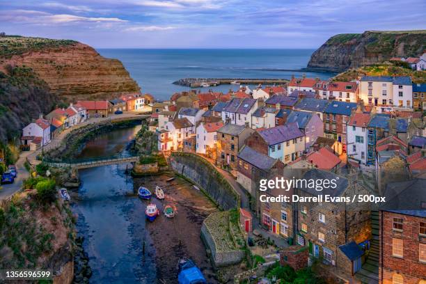 staithes at blue hour,high angle view of townscape by sea against sky,staithes,united kingdom,uk - north yorkshire stockfoto's en -beelden