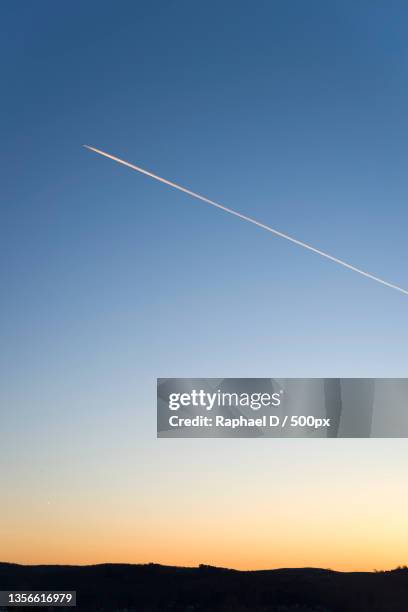 sunset vapor trails,scenic view of vapor trails in sky during sunset - sunset contrail stock pictures, royalty-free photos & images
