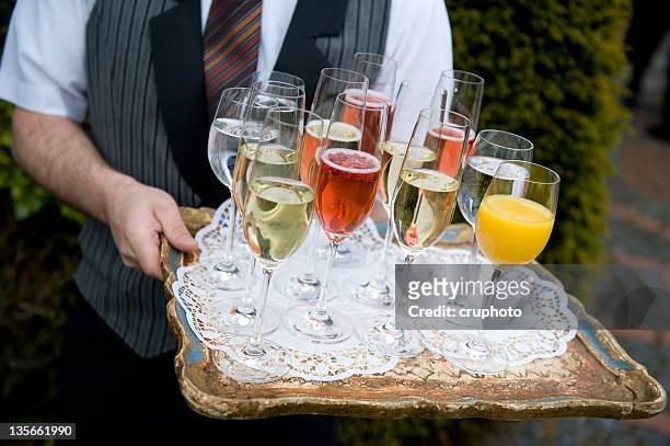 waiter holding a tray with champagne glasses at the wedding - vruchtensap stockfoto's en -beelden