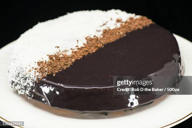 lamington mirror glaze cake,close-up of cake in plate on table - lamington cake stock pictures, royalty-free photos & images