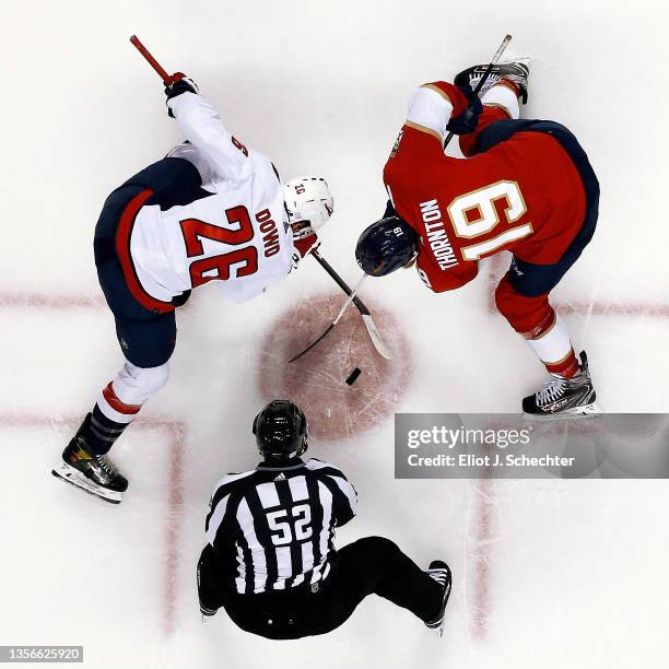 Linesmen Shandor Alphonso drops the puck for a face off between Nic Dowd of the Washington Capitals and Joe Thornton of the Florida Panthers at the...
