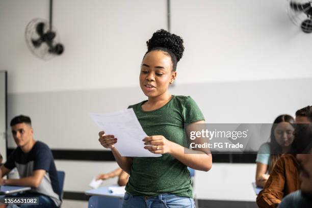 teeange student reading aloud in the classroom - students talking stock pictures, royalty-free photos & images