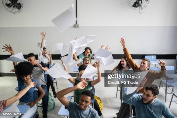 teenager students throwing paper in the air in the classroom - gymnasieexamen bildbanksfoton och bilder