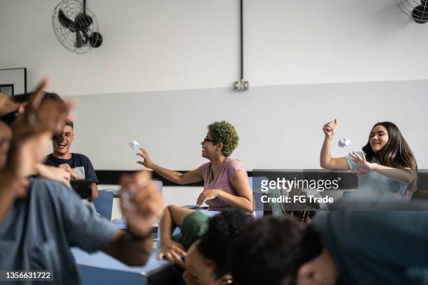 teenager students throwing paper balls at each other in the classroom - throwing paper stock pictures, royalty-free photos & images