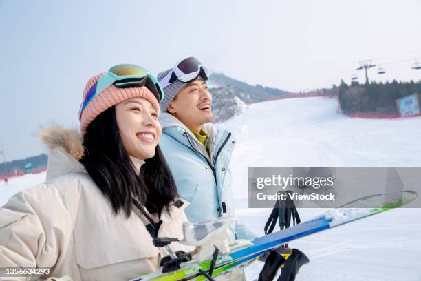 ski resorts on skis ski pole with the happy couple - ski pole stock-fotos und bilder