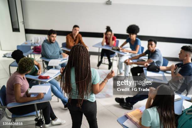 teenager-schüler, der eine präsentation im klassenzimmer hält - schüler von hinten im klassenzimmer stock-fotos und bilder