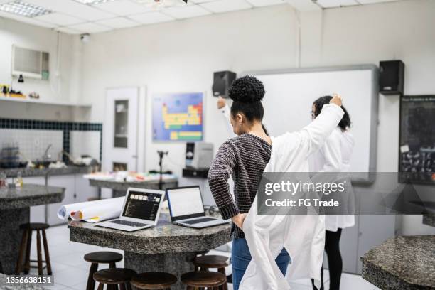 adolescentes chegam e usam jaleco no laboratório - laboratory coat - fotografias e filmes do acervo