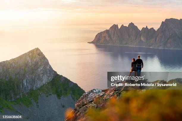 man and woman in love watching sunset, senja, norway - love on the rocks stock pictures, royalty-free photos & images