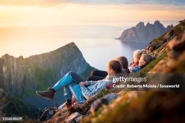 cheerful young women watching sunset, senja island, norway - wonderlust imagens e fotografias de stock
