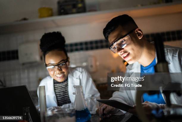 students doing an experiment while studying in a lab at school or university - dedication stock pictures, royalty-free photos & images
