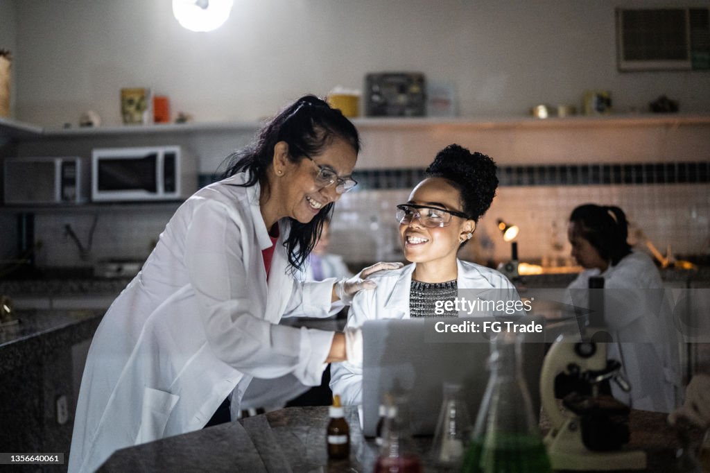 Chemistry teacher teaching students in the lab at school or university