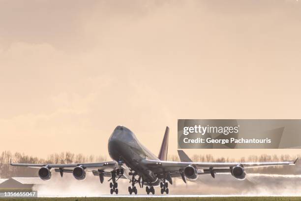boeing 747 taking off from a wet runway - 747 stock-fotos und bilder