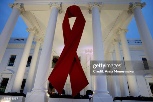 Red ribbon is displayed on the North Portico of the White House to recognize World AIDS Day on December 01, 2021 in Washington, DC. Earlier today...
