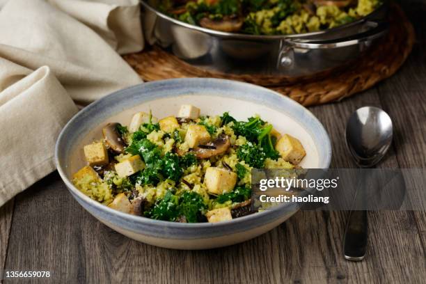 healthy vegan kale, mushroom, brown rice pilaf with fried tofu - pilafrijst stockfoto's en -beelden