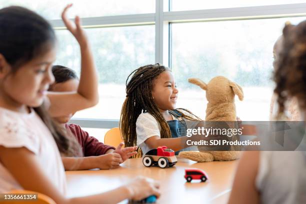 diverse group of children play at table with toys - stuffed toy stock pictures, royalty-free photos & images