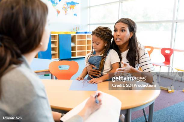 mom talks with teacher during parent-teacher conference - class argument stockfoto's en -beelden