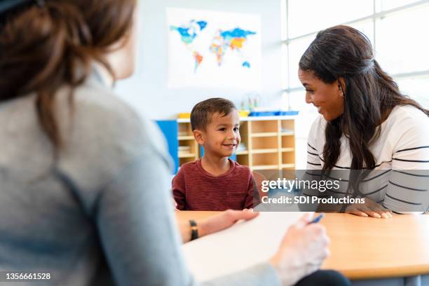 kinderpsychologe spricht mit kleinem jungen und seiner mutter - psychiatrie und psychotherapie stock-fotos und bilder