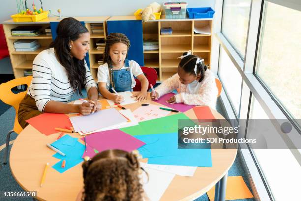 profesor ayuda a los estudiantes con proyecto de arte - papel para manualidades fotografías e imágenes de stock