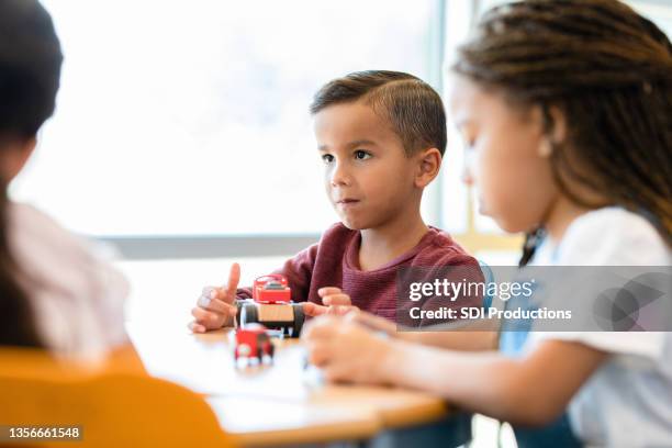 little boy plays with toy truck at daycare - toy truck stock pictures, royalty-free photos & images