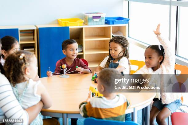 little girl asks question during kindergarten class - 5 years stock pictures, royalty-free photos & images