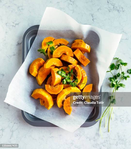 sliced, fresh butternut squash on parchment on a tray - butternut squash stock pictures, royalty-free photos & images