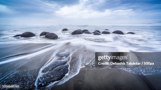 marbles in the tide,scenic view of sea against sky - moeraki stock pictures, royalty-free photos & images