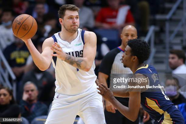 Luka Doncic of the Dallas Mavericks passes around Herbert Jones of the New Orleans Pelicans during the first half at Smoothie King Center on December...