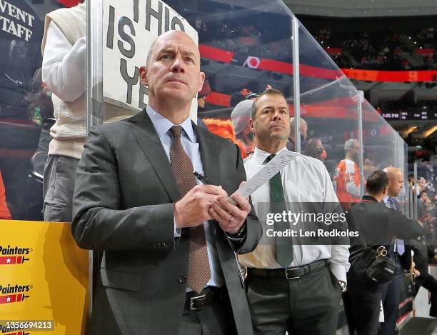 Assistant Coach Darryl Williams and Head Coach Alain Vigneault of the Philadelphia Flyers watch warm-up from the bench against the Carolina...